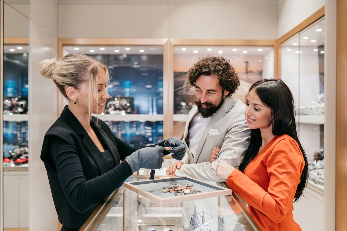 A jewelry associate helping a couple choose a piece in our store